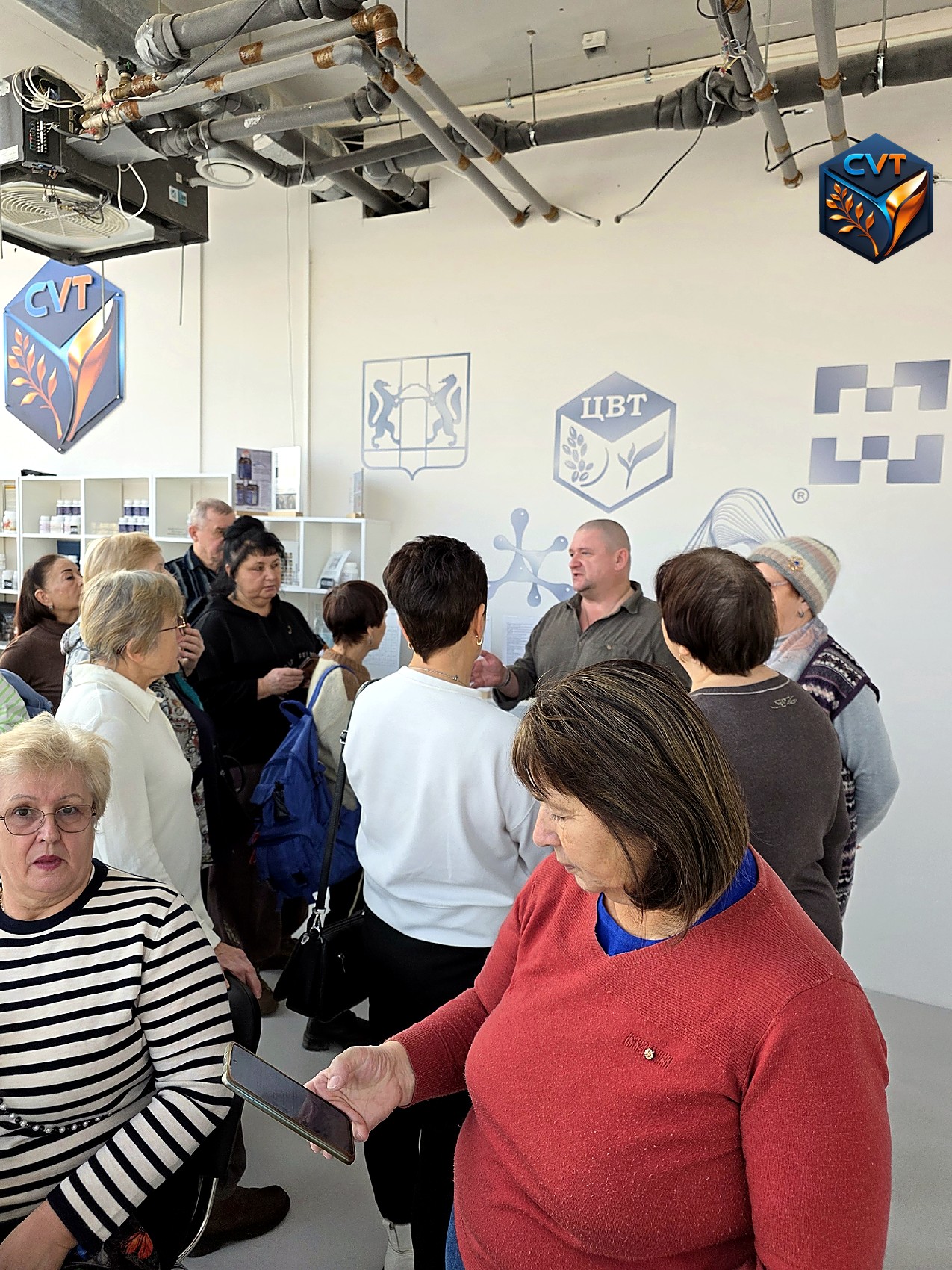 Гости в зале Центра внедрения технологий у стеллажей с продукцией