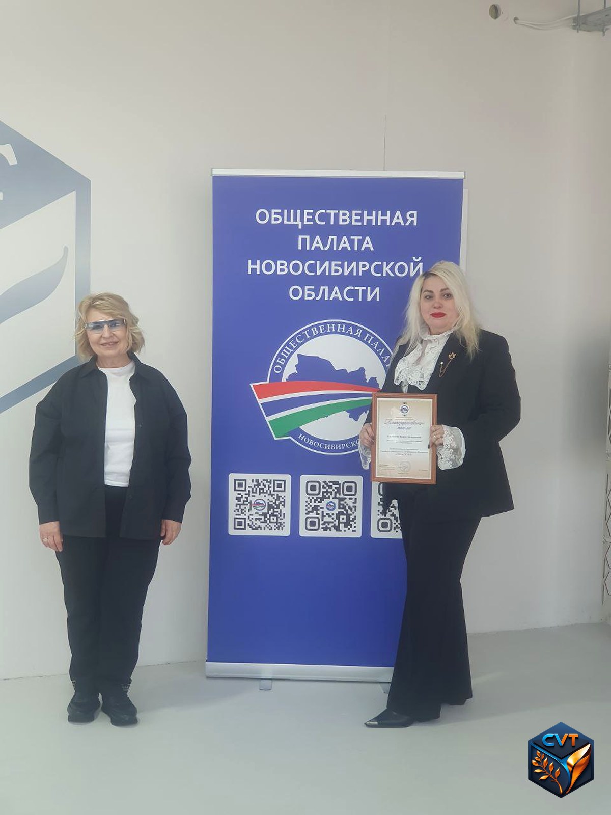 Вручение благодарности у баннера Общественной палаты Новосибирской области